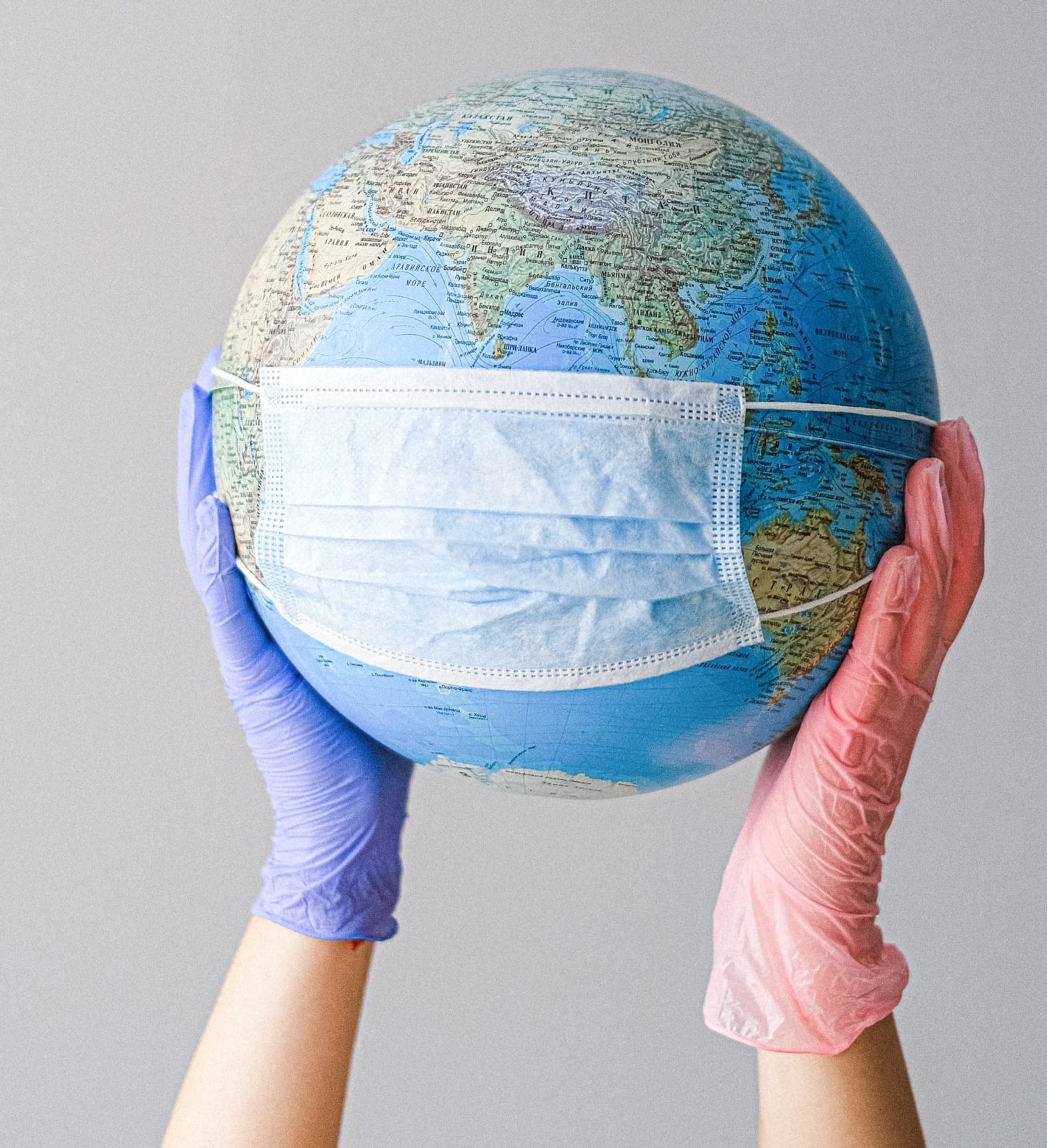 globe in some hands with gloves on
