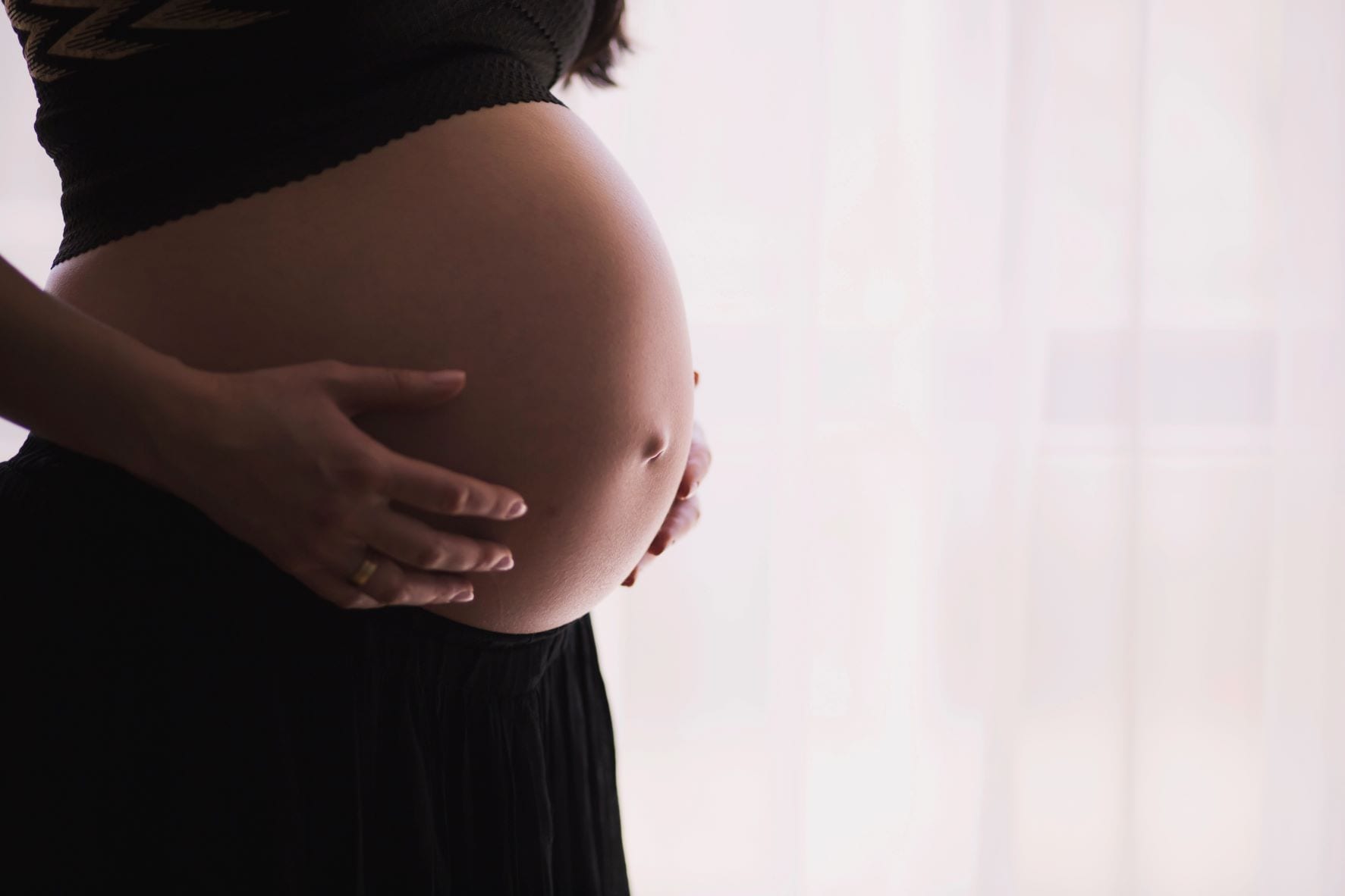 woman cradling pregnant belly