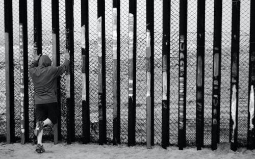 person at U.S. Mexico border wall
