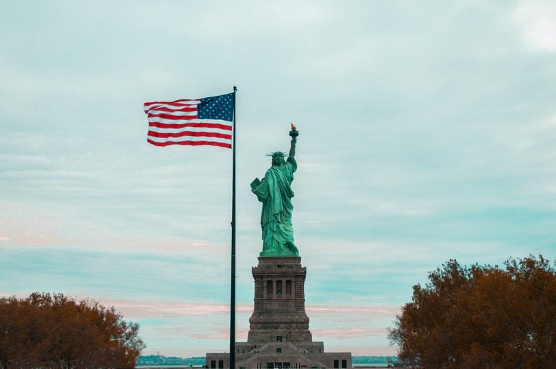 statue of liberty with an american flag